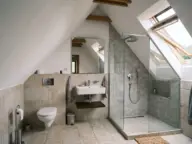 Baie de mansardă finisată, cu WC suspendat sub pantă și lavoar pe peretele de fronton